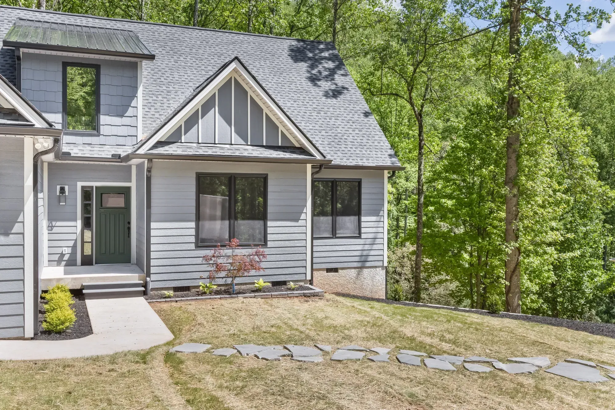 Covered front entry, board-and-batten gable and black-framed windows on a new Candler, NC custom home