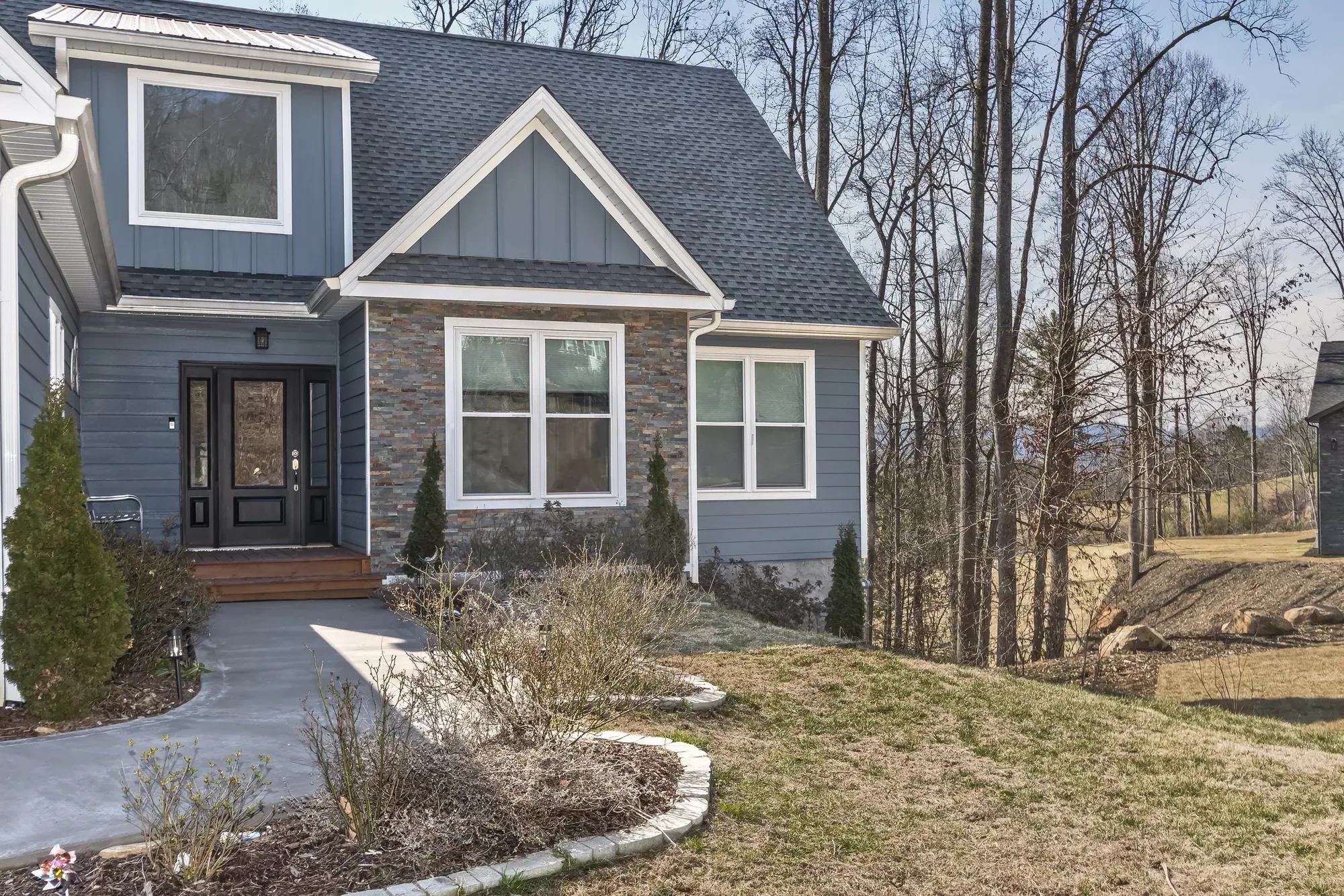 Front entry with a dark double-glass door and a stacked-stone bay on a Weaverville, NC custom home