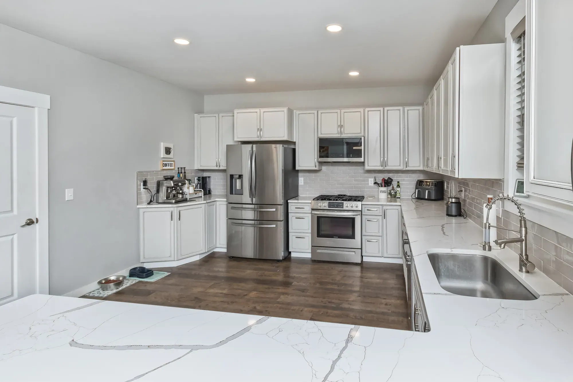 White kitchen with stainless appliances and an undermount sink in a Weaverville, NC custom home