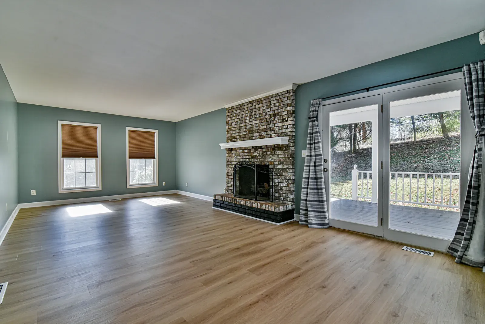 Living room with a fireplace and sliding glass doors to the rear deck in a Weaverville, NC home